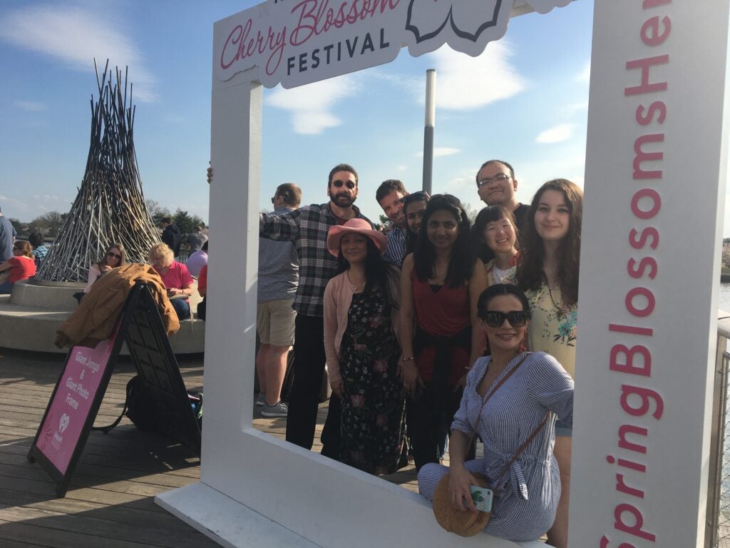 Attendees pose inside a decorative giant photo frame for the National Cherry Blossom Festival
