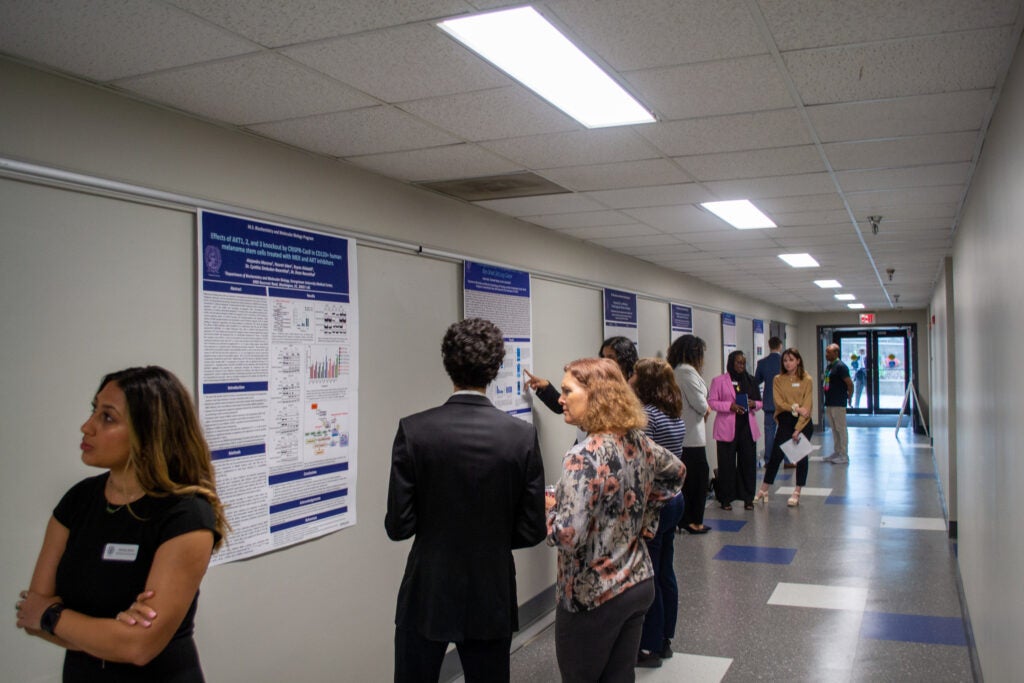 Students and faculty discuss poster presentations in Spring 2023