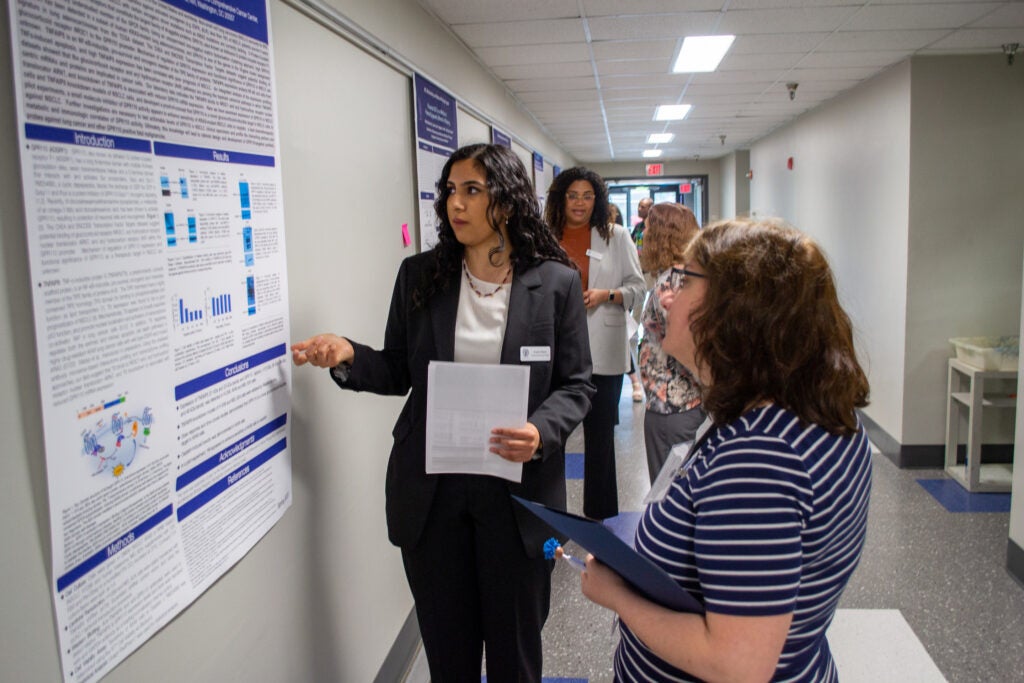 Students and faculty discuss poster presentations in Spring 2023