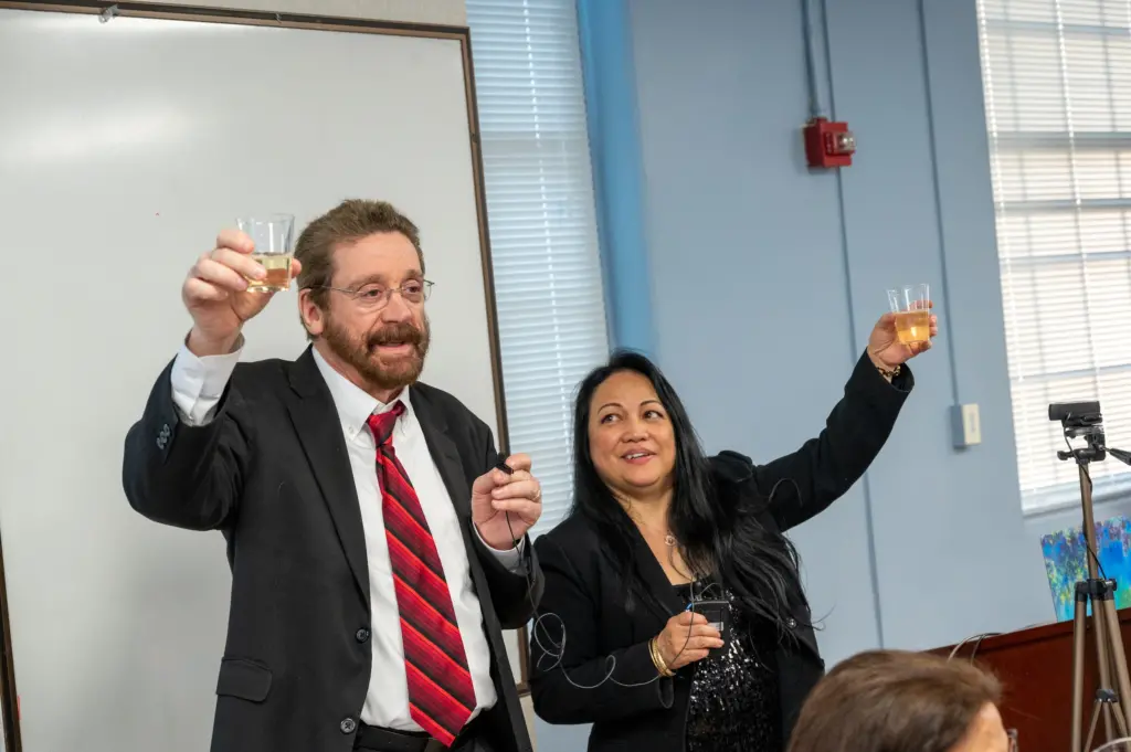Dr. Rosenthal and Dr. Simbulan-Rosenthal toast at the Spring 2023 Tropaia Ceremony