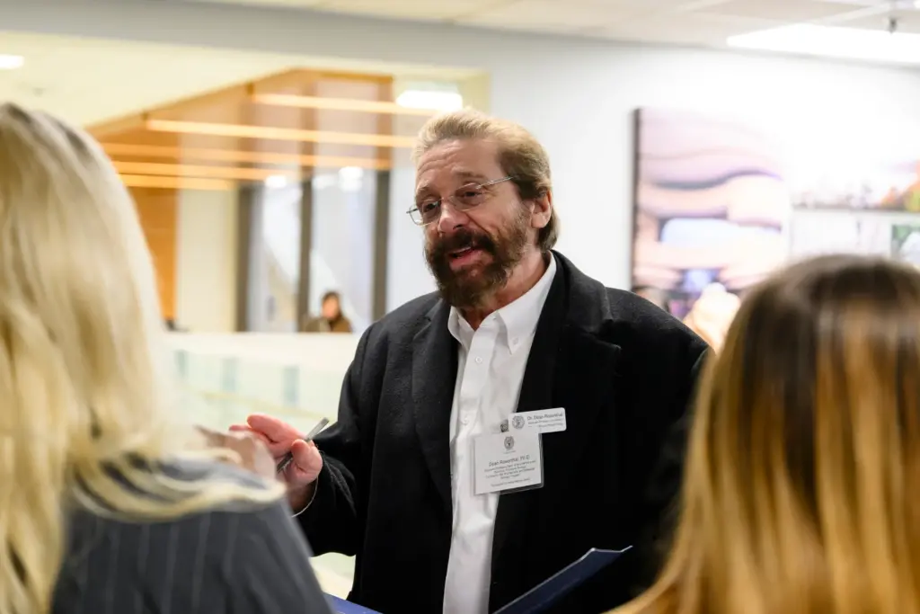 Dr. Rosenthal speaks to other attendees during the Fall 2023 internship presentations